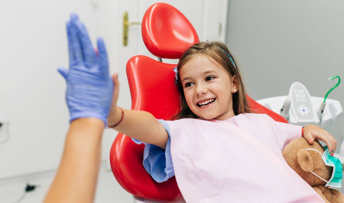 young girl giving dentist high-five